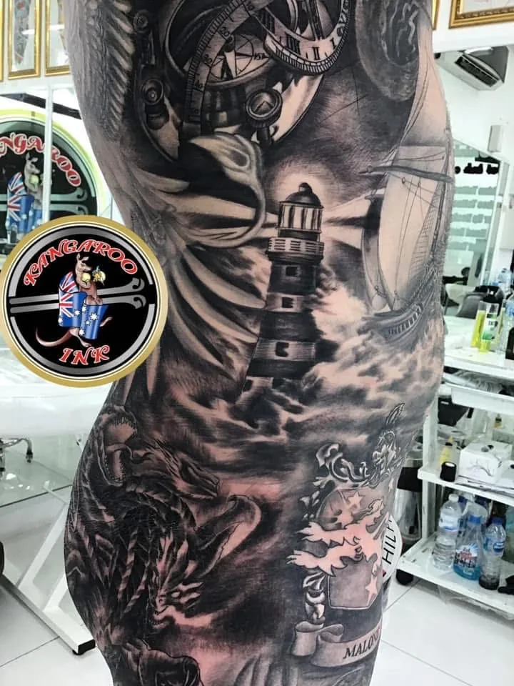 Large black and grey lighthouse sleeve tattoo by Kangaroo Ink Patong